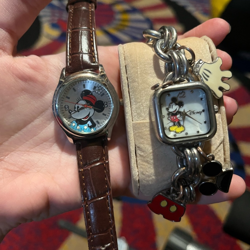 Two disney watches one with charm bracelet band and the other with leather